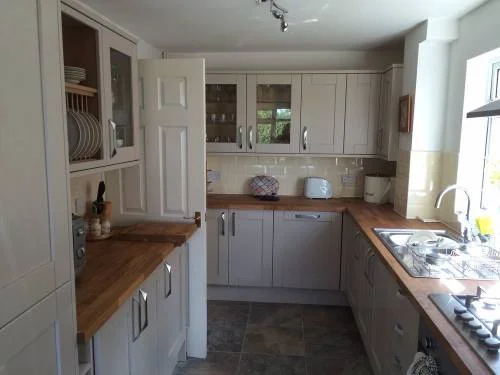 Fitted kitchen with grey cupboards and wooden worktops